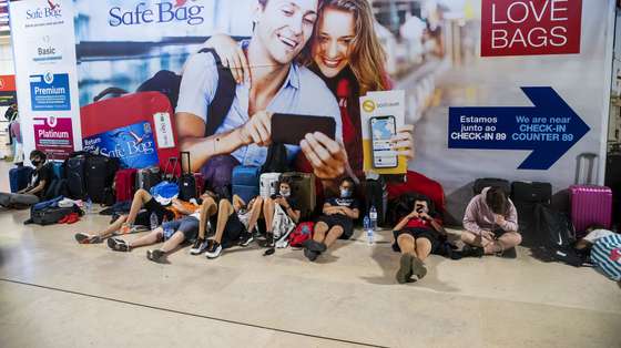 Passengers lay on the floor as they wait for their flight due to a strike of the handling company, Groundforce, which is causing major disruption in the Lisbon Airport, causing the cancelation of dozens of flights, in Lisbon, Portugal, 17 July 2021. Groundforce workers are protesting against colective dismissal of workers and low salaries. JOSE SENA GOULAO/LUSA