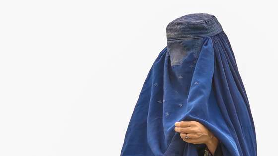 epa09414570 An Afghan burqa-clad women from northern provinces stands near her shelter after she fled from her home due to the fighting between Taliban and Afghan security forces, in a public park in Kabul, Afghanistan, 14 August (issued 15 August). The Taliban captured Mazar-i-Sharif, the country's fourth-largest city and the government's last major stronghold in the north on 14 August, as they tightened their grip on the country and closed in on Kabul. Most of the remote districts of the provinces have already fallen to the Taliban in the past three months.  EPA/HEDAYATULLAH AMID