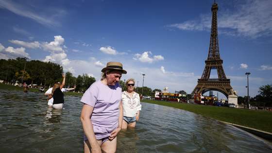 epa13052298 People cool off in the Trocadero Fountain by the Eiffel Tower, in Paris, France, 20 June 2026. An intense heatwave is gripping Western and Central Europe, pushing temperatures far above seasonal norms for mid-June.  EPA/YOAN VALAT