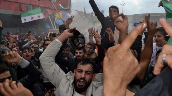 epa11764583 People shout slogans and carry Syrian flags of the opposition as they celebrate the rebel take over of Damascus, in Tripoli, northern Lebanon, 08 December 2024. Syrian rebels entered Damascus on 08 December 2024 and announced in a televised statement the 'Liberation of the city of Damascus and the overthrow of Bashar al-Assad,' as well as the release of all the prisoners. The rebels also urged the Syrian armed forces to leave Syrian public institutions, which will stay under the control of the outgoing Syrian prime minister until the official handover ceremony.  EPA/STR