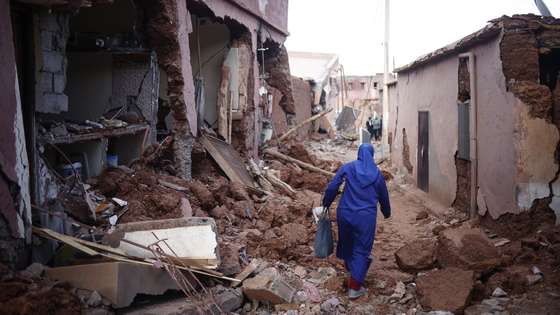 epa10853311 A woman passes by damaged buildings following a powerful earthquake in Ouirgane, south of Marrakesh, Morocco, 10 September 2023. A magnitude 6.8 earthquake that struck central Morocco late 08 September has killed at least 2,012 people and injured 2,059 others, 1,404 of whom are in serious condition, damaging buildings from villages and towns in the Atlas Mountains to Marrakesh, according to a report released by the country's Interior Ministry. The earthquake has affected more than 300,000 people in Marrakesh and its outskirts, the UN Office for the Coordination of Humanitarian Affairs (OCHA) said.  EPA/YOAN VALAT