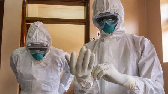 epa10255231 Ugandan doctors wear their Personal Protective Equipments at the Entebbe Regional Referral Hospital Isolation Centre in Entebbe, Uganda, 20 october 2022. A total of 64 positive cases and 24 deaths have so far been confirmed in Uganda since the outbreak of the deadly Ebola virus a month ago in Uganda.  EPA/ISAAC KASAMANI