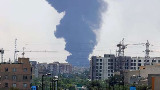 epaselect epa12176951 Smoke from an oil refinery rises over residential buildings in southern Tehran, Iran, 15 June 2025. Israel continued to target sites related to Iran's nuclear program and energy facilities, after launching strikes across Iran since 13 June. In retaliation, Iran launched waves of missiles and drones toward Israel.  EPA/ABEDIN TAHERKENAREH