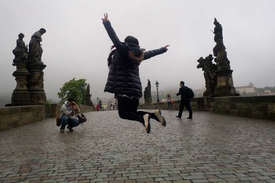 A tourist takes picture of his girlfriend jumping at the Charles Bridge on May 31, 2013 in Prague. AFP PHOTO/MICHAL CIZEK        (Photo credit should read MICHAL CIZEK/AFP/Getty Images)