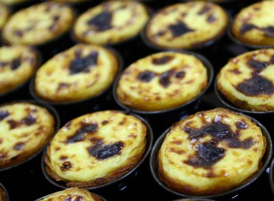 Lisbon, PORTUGAL:  TO GO WITH STORY BY LEVI FERNANDES Freshly made "Pasteis de Belem" line up on tray at Fabrica de Pasteis de Nata, in Lisbon 28 September 2006. The bakery started on 1837 to produce the Belem Pastries (a kind of custard tart), following an old secret recipie from the Jeronimos Monastery. AFP PHOTO/ FRANCISCO LEONG  (Photo credit should read FRANCISCO LEONG/AFP/Getty Images)