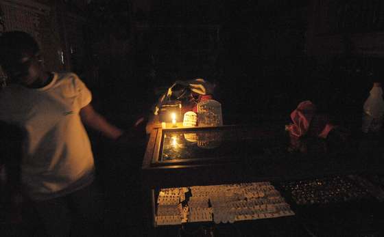 Vendors in one of the largest markets in Ivory Coast, the covered Adjame market in Abidjan, use candles on February 10, 2010 during a power outage. Ivory Coast, one of Africa's leaders in electricity supply, is enduring  power cuts because of a shortfall in production. The national electricity company, Ivorian Electricity Company (CIE), a subsidiary of the French group Bouygues, warned on February 1 that power cuts were likely to occur during the next three months.      AFP PHOTO / ISSOUF SANOGO (Photo credit should read ISSOUF SANOGO/AFP/Getty Images)