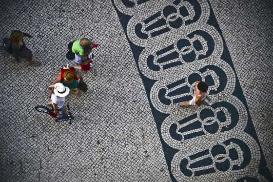 TO GO WITH AFP STORY BY LEVI FERNANDES People walk at Chiado, in Lisbon on June 22, 2013. The portuguese pavement is a tourism highlight when they visit Portugal and the graphics evoke the golden age of Portuguese discoveries and the relation with the sea, developed in the nineteenth century.    AFP PHOTO/ PATRICIA DE MELO MOREIRA        (Photo credit should read PATRICIA DE MELO MOREIRA/AFP/Getty Images)