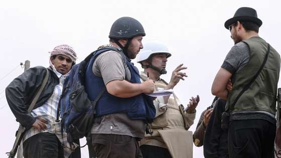 MISRATA, LIBYA - JUNE 02:   In this handout image made available by the photographer American journalist Steven Sotloff (Center with black helmet) talks to Libyan rebels on the Al Dafniya front line, 25 km west of Misrata on June 02, 2011 in Misrata, Libya.  Sotloff was kidnapped in August 2013 near Aleppo, Syria and was recently shown on a jihadist video in which fellow US journalist James Foley was executed.   In the video the militant form the Islamic State (IS) threatens to kill Sotloff next if the US continues its aerial campaign against the insurgency.  (Photo by Etienne de Malglaive via Getty Images)