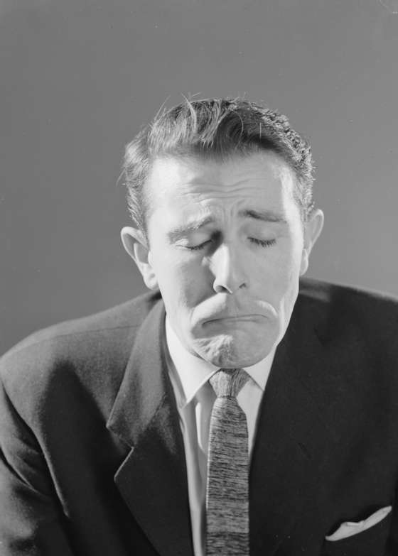 14th April 1960:  A man pulls a face like a little boy trying not to cry.  (Photo by Chaloner Woods/Getty Images)