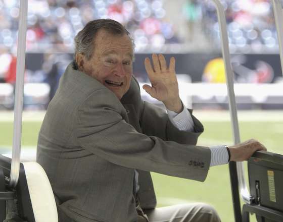 HOUSTON, TX - DECEMBER 01:  Former U.S. President George H.W. Bush waves during the game between the New England Patriots and the Houston Texans at Reliant Stadium on December 1, 2013 in Houston, Texas.  (Photo by Bob Levey/Getty Images)