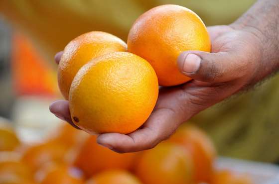 Customers buys oranges, a round-shaped fruit, at a market in suburban Manila on December 31, 2009. Some Filipinos believe that displaying 12 different round-shaped fruits - one representing each month of the year - at home before New Year's Day welcomes prosperity.     AFP PHOTO / JAY DIRECTO (Photo credit should read JAY DIRECTO/AFP/Getty Images)