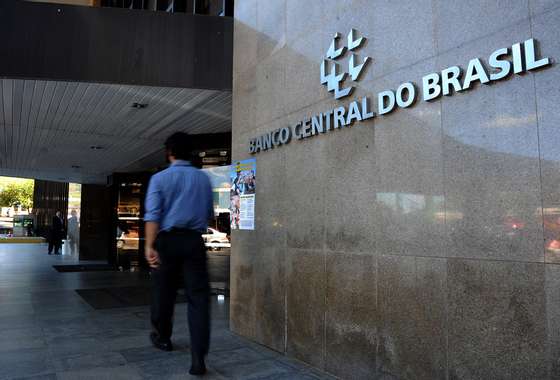 A man arrives at the Brazilian Central Bank building in Brasilia, on May 29, 2012. Brazil's Monetary Policy Committee (COPOM) will decide today the new target interest rate, which traders expect will probably be reduced 0.5% from the current 9%.  AFP PHOTO/PEDRO LADEIRA        (Photo credit should read PEDRO LADEIRA/AFP/GettyImages)