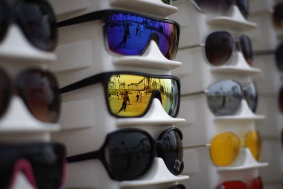 VENICE, CA - JULY 6:  People are reflected in sunglasses for sale on the boardwalk on Independence Day weekend at Venice Beach on July 6, 2013 in Venice, California. An estimated 16 million people visit the famous beach city annually which is celebrating 108th birthday as of July 4.   (Photo by David McNew/Getty Images)