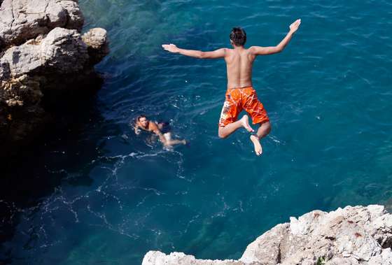 A child jumps in the Mediterranean Sea on July 26, 2013 in Nice, southeastern France.  AFP PHOTO / VALERY HACHE        (Photo credit should read VALERY HACHE/AFP/Getty Images)