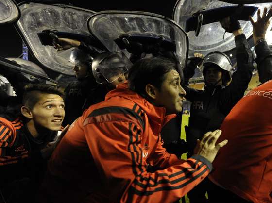 Argentina's River Plate footballers leave the pitch under police shields after the match was suspend when Boca Juniors fans pepper sprayed River Plate players before the start of the second half of the Copa Libertadores 2015 second leg football match against Argentina's Boca Juniors at the "Bombonera" stadium in Buenos Aires, Argentina, on May 15, 2015. AFP PHOTO / JUAN MABROMATA        (Photo credit should read JUAN MABROMATA/AFP/Getty Images)