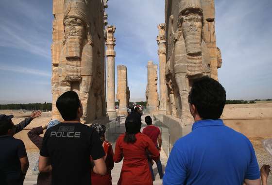 PERSEPOLIS, IRAN - MAY 30:  Tourists gaze upon the Gate of All Nations at the ancient Persepolis archeological site on May 30, 2014 in Persepolis, Iran. The ruins mark the site of the 6th century BC Persian Achaemenid Empire, the largest empire the world had known up to that time, eventually ended by Alexander the Great. This week marks the 25th anniversary of the death and continued legacy of the Ayatollah Khomeini, the father of Iran's Islamic Revolution, only the latest chapter of Persia's long history.  (Photo by John Moore/Getty Images)