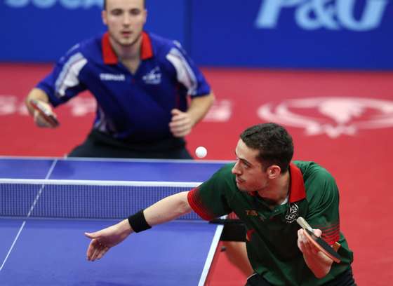 epa04801108 Marcos Freitas (R) of Portugal serves the ball to Simon Gauzy of France during the gold medal match of the men's Table Tennis team event at the Baku 2015 European Games in Baku, Azerbaijan, 15 June 2015.  EPA/ZURAB KURTSIKIDZE