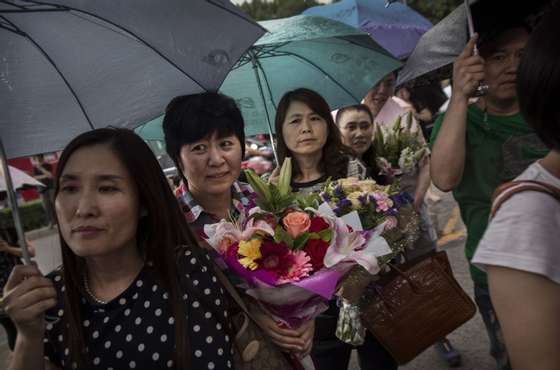 BEIJING, CHINA - JUNE 08: Parents of Chinese students wait in the rain outside of the Beijing Renmin University Affiliated High School, one of the most prestigious in the country, as they wait for their children to finish writing the Gaokao on June 8, 2015 in Beijing, China. Students spend months preparing for the annual exam and its also a stressful time for parents as the results determine a student's educational path and dictates future job prospects. More than 9 million students across China took the test over the last two days. (Photo by Kevin Frayer/Getty Images)