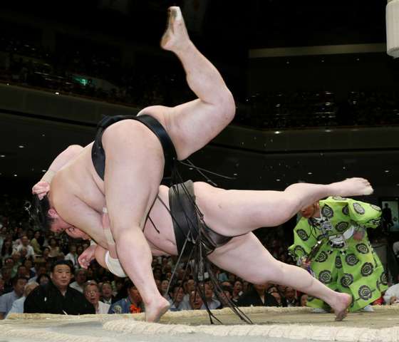 Sumo grand champion Hakuho (top) is thrown by champion Goeido on the 12th day bout of the Summer Grand Sumo Tournament in Tokyo on May 21, 2015. Hakuho lost the match but still leads the 15-day tournament 10-2. AFP PHOTO / JIJI PRESS JAPAN OUT (Photo credit should read JIJI PRESS/AFP/Getty Images)