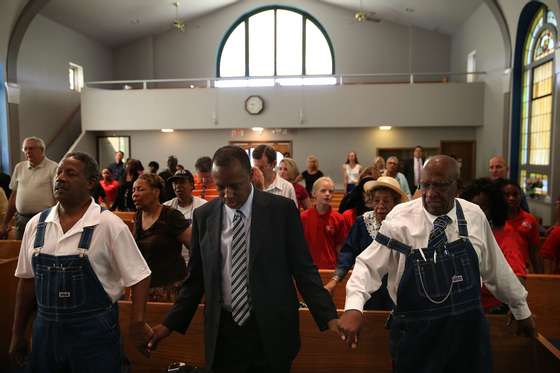 DES MOINES, IA - AUGUST 16: Republican presidential hopeful Ben Carson (C) prays during church services at Maple Street Missionary Baptist Church on August 16, 2015 in Des Moines , Iowa. Ben Carson attended Sunday church services before campaigning at the Iowa State Fair. (Photo by Justin Sullivan/Getty Images)