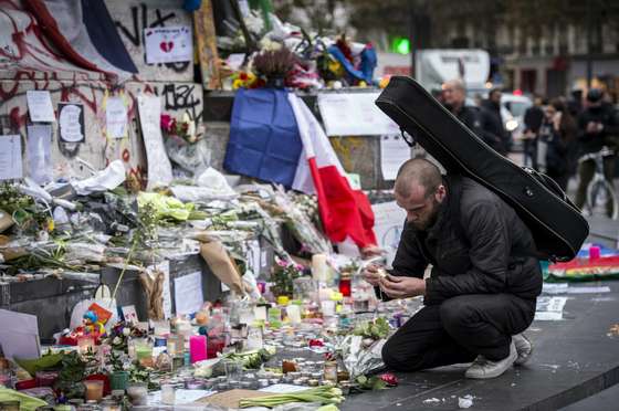 A man lights a candle amongst tributes laid to victims of the Paris attacks at the foot of the Monument a La Republique in Paris on November 16, 2015. Islamic State jihadists claimed a series of coordinated attacks by gunmen and suicide bombers in Paris on November 13 that killed at least 129 people in scenes of carnage at a concert hall, restaurants and the national stadium. AFP PHOTO / LIONEL BONAVENTURE (Photo credit should read LIONEL BONAVENTURE/AFP/Getty Images)