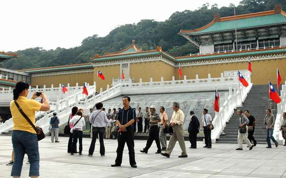 TO GO WITH: FINANCE-ECONOMY-TAIWAN-CHINA-TOURISM by Amber Wang Chinese tourists take pictures outside Taiwan's popular sight-seeing spot the National Palace Museum in Taipei on October 26, 2008. Taiwanese authorities were counting on the mainland visitors to bring in 60 billion Taiwan dollars (1.87 billion US) annually in a major boost to its tourism but despite the rapprochement between the two sides, fewer than 300 Chinese visitors came to the island on average every day since July. AFP PHOTO/PATRICK LIN (Photo credit should read PATRICK LIN/AFP/Getty Images)