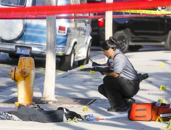 A police officer investigates the scene near Pearson Park in Anaheim, California, February 27, 2016, after three counter-protesters were stabbed while clashing with Ku Klux Klan members staging a rally. Thirteen people were arrested. / AFP / RINGO CHIU (Photo credit should read RINGO CHIU/AFP/Getty Images)
