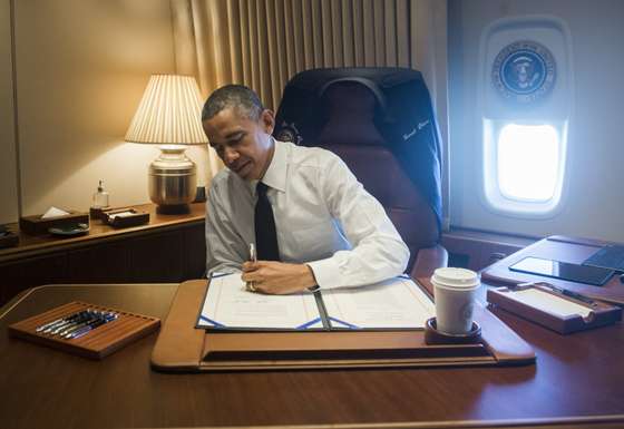 US President Barack Obama signs a bill that will give the Congressional Gold Medal to the Foot Soldiers who Participated in Bloody Sunday in Selma, Alabama, in his office aboard Air Force One as he flies to Alabama on March 7, 2015. Obama is traveling to participate in an event commemorating the 50th anniversary of Bloody Sunday, when civil rights marchers attempting to walk to the Alabama capital of Montgomery to end voting discrimination against African Americans clashed with police. AFP PHOTO / SAUL LOEB (Photo credit should read SAUL LOEB/AFP/Getty Images)