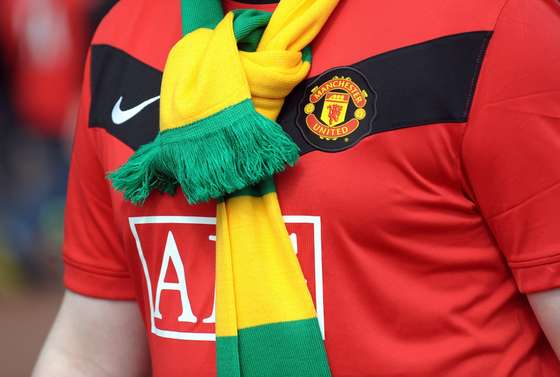 A Manchester United supporter wears a green and gold scarf in protest against the Glazer family's owenership of the club ahead of their English Premier League football match against Tottenham Hotspur at Old Trafford in Manchester, north-west England, on April 24, 2010. AFP PHOTO/PAUL ELLIS - FOR EDITORIAL USE ONLY Additional licence required for any commercial/promotional use or use on TV or internet (except identical online version of newspaper) of Premier League/Football League photos. Tel DataCo +44 207 2981656. Do not alter/modify photo. (Photo credit should read PAUL ELLIS/AFP/Getty Images)