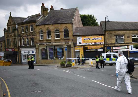 A police forensic officer prepares to work at the scene in Birstall where Labour MP Jo Cox was shot on June 16, 2016. Campaigning for Britain's EU referendum next week was suspended on Thursday following news a leading MP with the "Remain" camp was in a critical condition after being shot. Jo Cox, a 41-year-old mother-of-two from the opposition Labour Party, was left bleeding on the pavement after the incident in the town of Birstall in northern England, according to witnesses quoted by local media. / AFP / OLI SCARFF (Photo credit should read OLI SCARFF/AFP/Getty Images)