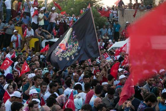 Supporters wave an ottoman flag as Turkish President (unseen) arrives during a rally near his house in Istanbul on July 16, 2016 after Turkish authorities wrested back control of the Ataturk airport.  President Recep Tayyip Erdogan urged Turks to remain on the streets on July 16, 2016, as his forces regained control after a spectacular coup bid by discontented soldiers that claimed more than 250 lives. Describing the attempted coup as a "black stain" on Turkey's democracy, Yildirim said that 161 people had been killed in the night of violence and 1,440 wounded. / AFP / GURCAN OZTURK        (Photo credit should read GURCAN OZTURK/AFP/Getty Images)