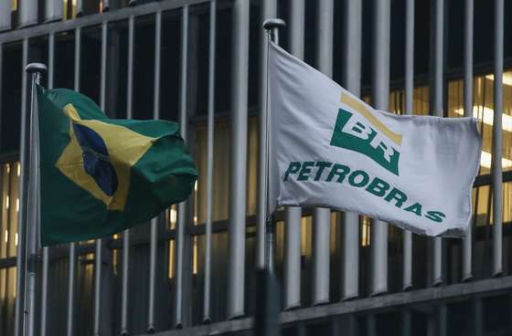 RIO DE JANEIRO, BRAZIL - APRIL 13: A Brazilian flag and a Petrobras flag fly in front of Petrobras headquarters on April 13, 2016 in Rio de Janeiro, Brazil. A massive corruption scandal at the state-owned oil company has sparked a political crisis in Brazil. President Dilma Rousseff, who has not been linked to the corruption scandal, was chairwoman of the Petrobras board from 2003-2010. President Rousseff is now facing impeachment with an initial vote set in the lower house of Congress for Sunday. (Photo by Mario Tama/Getty Images)
