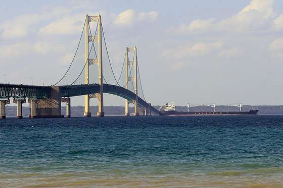 A ship is seen passing beneath the Mackinaw Bridge July 27, 2008 as seen from Mackinaw City, MI.The Mackinac Bridge straddles the Straits of Mackinac connecting Michigan's upper and lower peninsulas. Building it took three years, 2,500 men, 85,000 blueprints, 71,300 tons of structural steel, 466,3000 cubic yards of concrete, 41,000 miles of cable wire and millions of steel rivets and bolts. AFP PHOTO/Karen BLEIER (Photo credit should read KAREN BLEIER/AFP/Getty Images)
