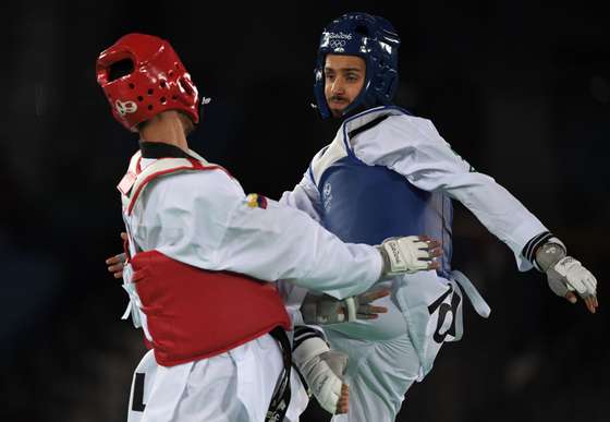 Portugal's Rui Braganca (R) competes against Colombia's Oscar Luis Munoz Oviedo during their men's taekwondo qualifying bout in the -58kg category as part of the Rio 2016 Olympic Games, on August 17, 2016, at the Carioca Arena 3, in Rio de Janeiro. / AFP / Ed JONES (Photo credit should read ED JONES/AFP/Getty Images)