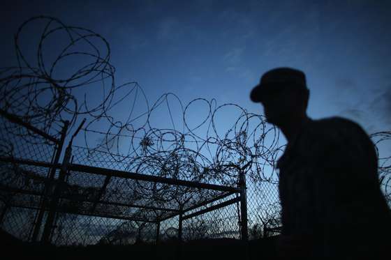 GUANTANAMO BAY, CUBA - JUNE 27: (EDITORS NOTE: Image has been reviewed by the U.S. Military prior to transmission.) A Public Affairs Officer escorts media through the currently closed Camp X-Ray which was the first detention facility to hold 'enemy combatants' at the U.S. Naval Station on June 27, 2013 in Guantanamo Bay, Cuba.The U.S. Naval Station at Guantanamo Bay, houses the American detention center for 'enemy combatants'. President Barack Obama has recently spoken again about closing the prison which has been used to hold prisoners from the invasion of Afghanistan and the war on terror since early 2002. (Photo by Joe Raedle/Getty Images)