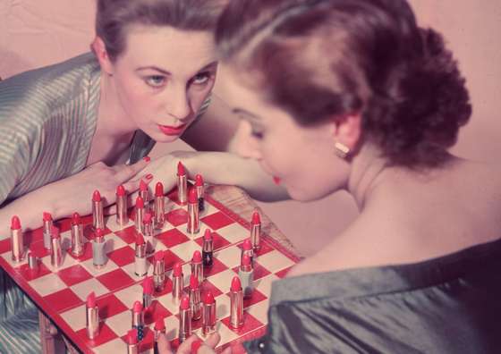 circa 1955: Two women playing an unusual game of chess, with lipstick instead of chess pieces. (Photo by Chaloner Woods/Getty Images)