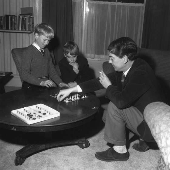 1961: English novelist and poet Kingsley Amis (1922 - 1995) with his sons Martin and Philip playing chess. (Photo by Chris Ware/Keystone Features/Getty Images)