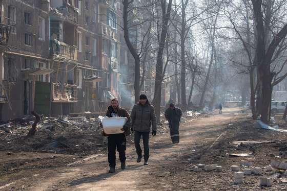 Men emerge to procure supplies in their still burning