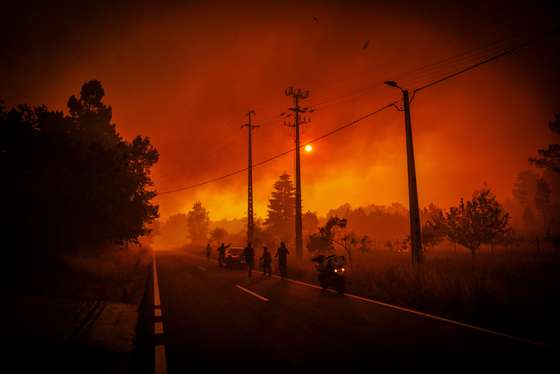 People wtach the fire and clouds of smoke during a forest fire in Granja do Paiva, Sernancelhe, Viseu, Portugal, 14 August 2025. The fire that started early Wednesday morning in Satao, in the district of Viseu, spread to the districts of Sernancelhe (Viseu) and Aguiar da Beira (Guarda) and, in the late afternoon, was still raging with no possibility of direct combat, according to the commander on the ground. PEDRO SARMENTO COSTA/LUSA