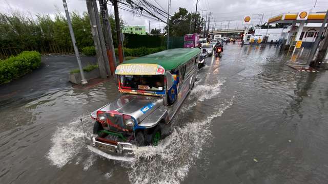 epa10272566 A Jeepney, a popular and uniquely Filipino mode of mass transport, drives through a flooded road in Las Pinas city, Metro Manila, Philippines, 29 October 2022. Data from the National Disaster Risk Reduction and Management Council (NDRRMC) showed that 45 people died from the effects of Typhoon Nalgae as of 29 October. Tracking by the country’s weather bureau places the typhoon in the southern Luzon region moving in a west southwestward direction.  EPA/FRANCIS R. MALASIG