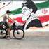 epa13165935 An Iranian man passes with his bike next to a wall painting featuring late Iranian supreme leader Ayatollah Ali Khamenei in a street in central Tehran, Iran, 13 August 2026. Tensions between Iran and the US remain high as opposing claims persist over shipping control in the Strait of Hormuz.  EPA/ABEDIN TAHERKENAREH RESTRICTIONS: NO Access Israel Media/Persian Language TV Stations Outside Iran/Strictly No Access BBC Persian/VOA Persian/Manoto TV/Iran International TV. (As mandated by Iran's Directorate General for Foreign Media) --