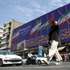 epa13145092 An Iranian woman walks past a billboard displaying the flags of Iran and Palestine on a street in Tehran, Iran, 01 August 2026. Tensions between Iran and the United States over the Strait of Hormuz continue after US President Donald Trump signalled on 31 July 2026 that further US strikes against Iran were possible.  EPA/ABEDIN TAHERKENAREH RESTRICTIONS: NO Access Israel Media/Persian Language TV Stations Outside Iran/Strictly No Access BBC Persian/VOA Persian/Manoto TV/Iran International TV. (As mandated by Iran's Directorate General for Foreign Media) -- RESTRICTIONS: ISRAEL OUT - NO ACCESS ISRAEL MEDIA/PERSIAN LANGUAGE TV STATIONS OUTSIDE IRAN/STRICTLY NO ACCESS BBC PERSIAN/VOA PERSIAN/MANOTO TV/IRAN INTERNATIONAL TV