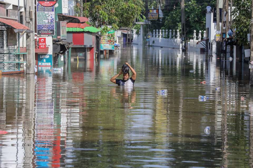 epa12559521 A person wades through a flooded road after heavy rainfall in a suburb of Colombo, Sri Lanka, 30 November 2025. Many parts of the island have been inundated due to heavy rains. According to the Sri Lanka Disaster Management Center, more than 160 people have been killed and about 200 are missing around the country.  EPA/CHAMILA KARUNARATHNE