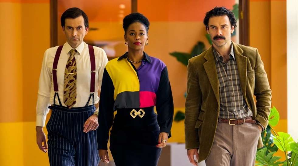 David Tennant, Nafessa Williams e Aidan Turner, nos corredores da estação televisiva Corinium, onde boa parte da ação de "Rivais" acontece