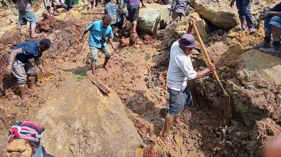 epa11373826 A handout photo made available by the International Organzation for Migration (IOM), shows local inhabitants digging in the rubble using spades and wooden sicks to serach for missing relatives at the landslide site in Tuliparo village, Yambali Ward, Maip Muli LLG, Porgera District,Papua New Guinea, 26 May 2024. (Issued 27 may 2024). According to a senior official with the IOM, on 26 May, more than 670 people are feared dead, after a landslide hit the Higlands region of Papua New Guinea on early 24 May. " the community in Yambali village, situated at the foot of a mountain in the remote Enga Province, is buried under between six to eight metres of soil. 150 houses are believed to be buried" he added.  EPA/MOHAMUD OMER/IOM/ HANDOUT  HANDOUT EDITORIAL USE ONLY/NO SALES HANDOUT EDITORIAL USE ONLY/NO SALES