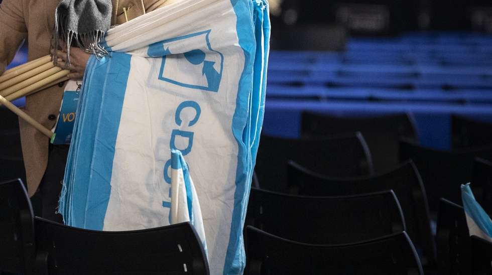 Um membro do CDS-PP coloca bandeiras nas cadeiras durante encerramento do 29.º Congresso do partido, no pavilhão Multiusos de Guimarães, 3 de abril de 2022. JOSÉ COELHO/LUSA