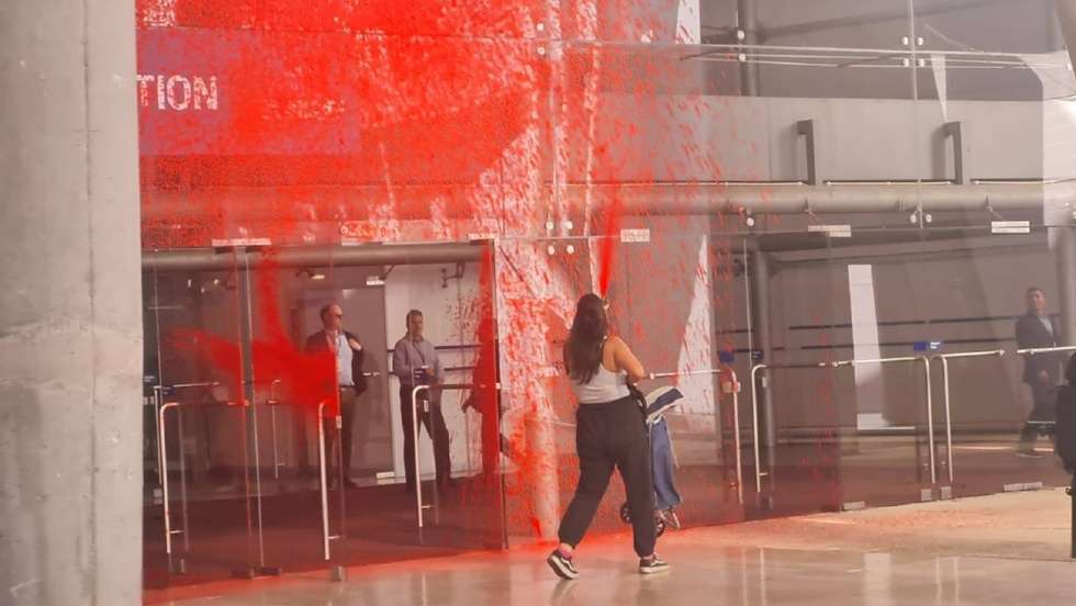 Ativista a pintar de vermelho uma das entradas da FIL
