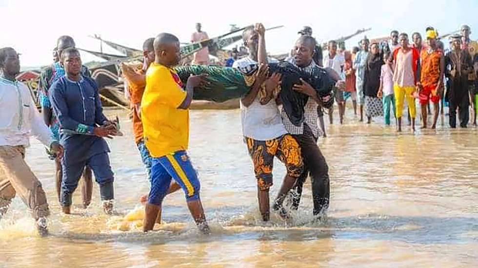 epa09231147 Nigerians carry the body of a drowned victim following a boat accident in Kebbi, Nigeria 26 May 2021 (issued 27 May 2021). According to Nigeria government authorities more than 100 are missing following a boat accident in the northwestern Nigerian state of Kebbi. The vessel had around 180 onboard when it split in half and sank.  EPA/STR BEST QUALITY AVAILABLE