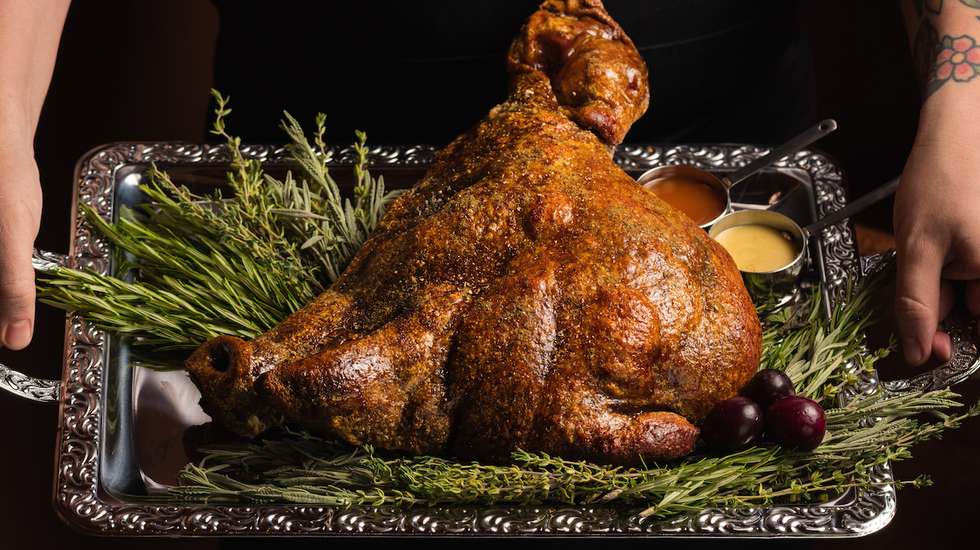 Um petisco para quatro: cabeça de porco assada com puré de batata, salada verde e molho de carne, um dos pratos principais do Origem