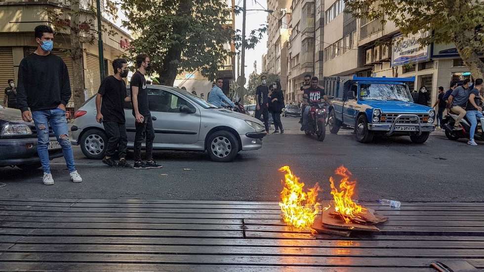 epa10231839 Protesters set a fire as they clash with police during a protest over the death of young Iranian woman Mahsa Amini, who died on 16 September after being arrested in Tehran for not wearing her hijab appropriately, in Tehran, Iran, 09 October 2022. Amini, a 22-year-old Iranian woman, was arrested in Tehran on 13 September by the morality police, a unit responsible for enforcing Iran's strict dress code for women. According to the police, she fell into a coma and died of heart failure, while her family says that she had no prior health conditions. Her death has triggered protests in various areas in Iran and around the world. According to Iran's state news agency IRNA, Iranian President Ebrahim Raisi expressed his sympathy to the family of Amini on a phone call and assured them that her death will be investigated carefully. Chief Justice of Iran Gholam-Hossein Mohseni-Eje'i assured her family that upon its conclusion, the investigation results by the Iranian Legal Medicine Organization will be announced without any special considerations  EPA/STR